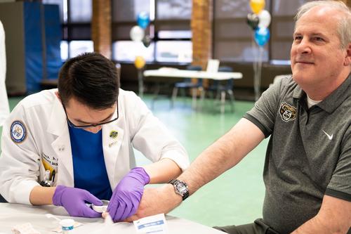 An image of Bob Noiva and student at a community health fair